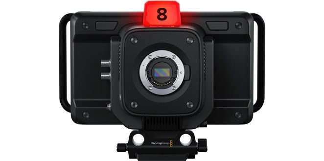 Black studio camera with front lens, top red tally, rig handles, compact body