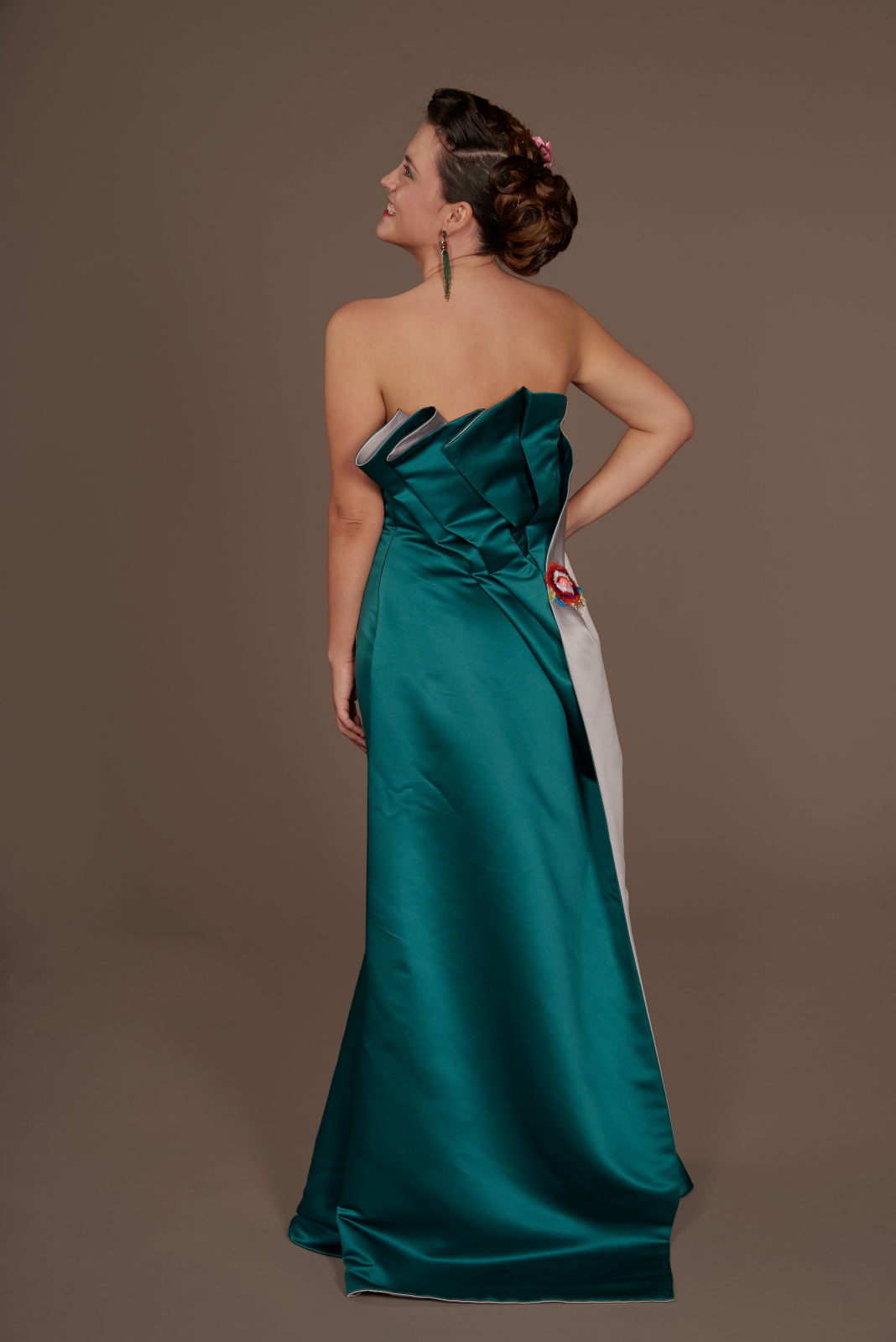 Photo backdrop sheet in studio, with model wearing a teal strapless dress