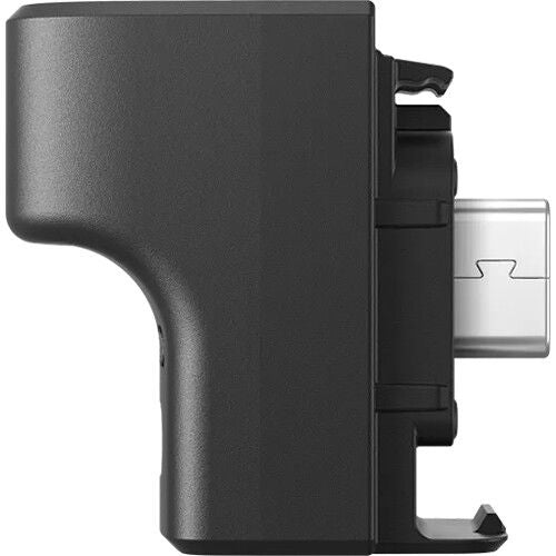 Side view of dark gray microphone adapter with clip mount and rear connector opening