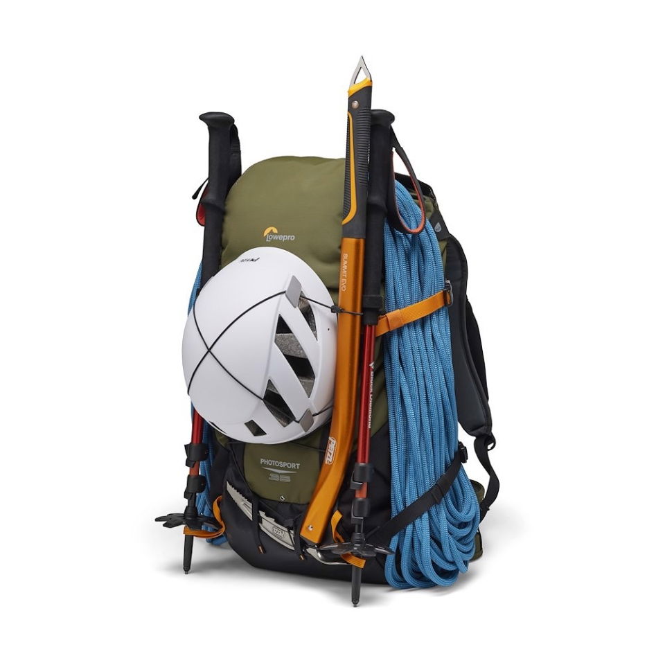 Olive camera backpack with orange accents carrying a white ball, tripod, and blue rope