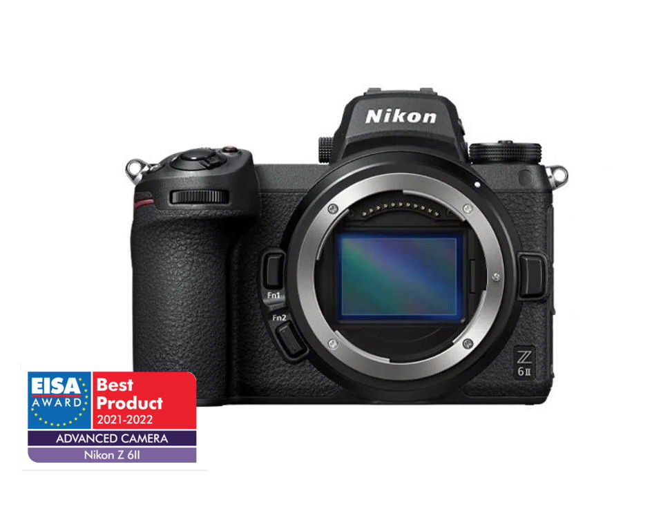 Front view of black mirrorless camera with mounted lens and control dials