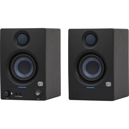 Black studio monitor speaker with blue-lit controls and front tweeter/woofer grilles.