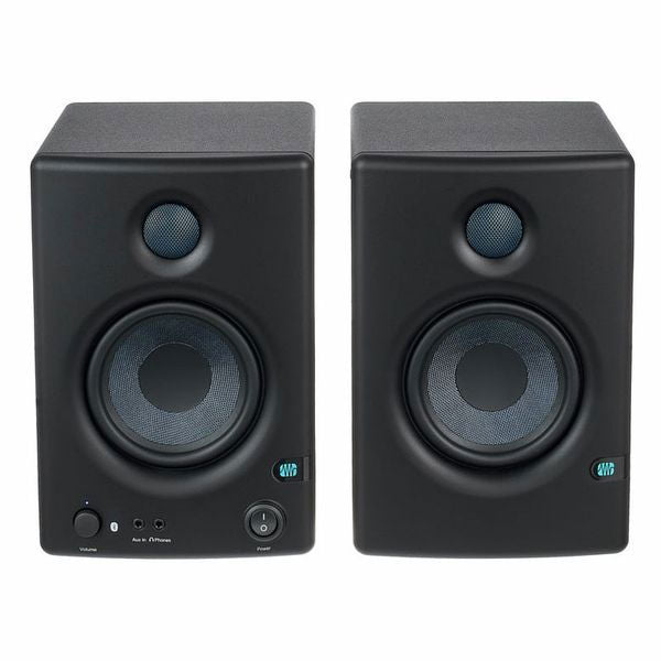 Black studio monitor speakers front view, volume and input controls on lower panel