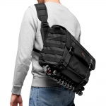 Black crossbody camera bag worn on shoulder with adjustable strap