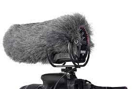 Gray furry microphone windscreen with mounting bracket on a video camera