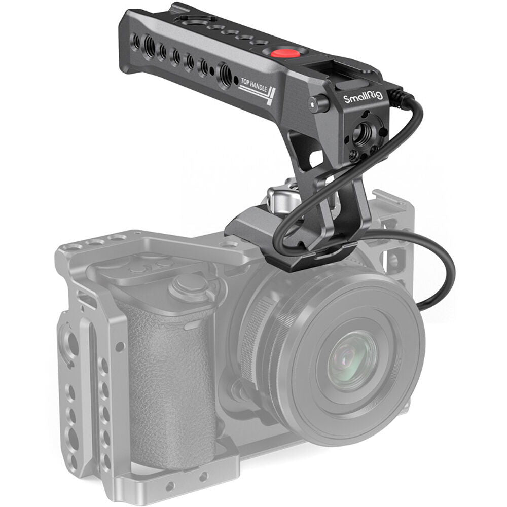 NATO top handle mounted on camera rig, red button and mounting holes, dark metal