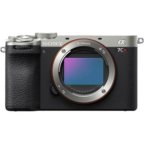 Mirrorless camera body front view, silver and black with lens mount and EVF window