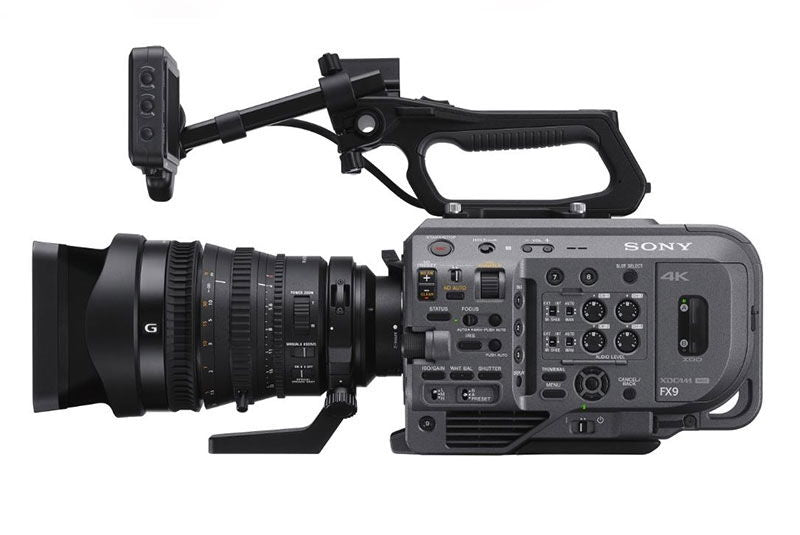 Cinema camera with 28-135mm lens, side view showing lens barrel and controls