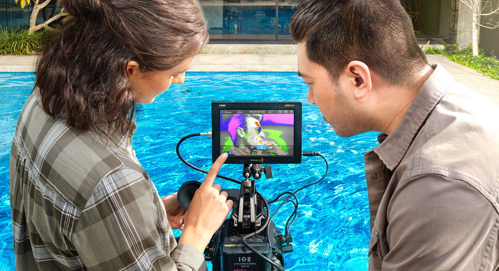 5-inch recorder monitor in outdoor setup, crew viewing camera feed on screen