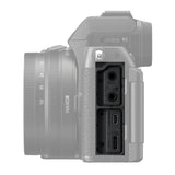 Light-colored camera side close-up with MIC and charging ports beside 16-50mm lens