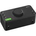 Black USB audio interface with top knob, buttons, and green status LED
