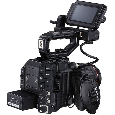 Cinema camera with flip-out monitor, handle grips, and visible connected cables
