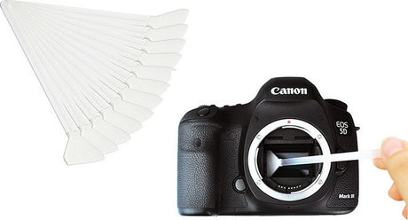 Set of white sensor cleaning swabs with triangular tips, shown near camera mount
