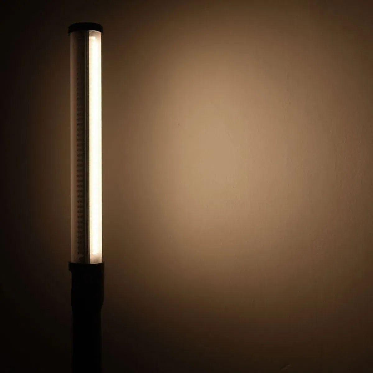 Upright LED stick bicolor light glowing white with long black housing and slim tube