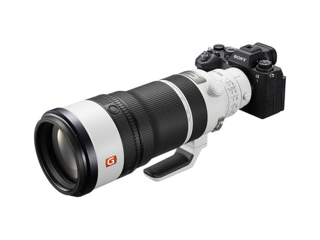 White and black 100-400mm telephoto lens mounted on mirrorless camera