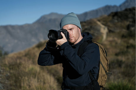 Photographer holding a mirrorless camera, beanie and jacket—Sony A7R VI