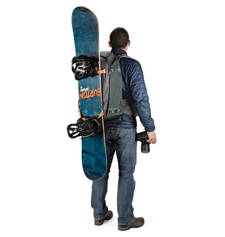 Worn grey camera backpack with orange straps and padded back panel for gear