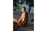 Model posing on concrete in warm light; camera not visible (A7R VI mirrorless body)