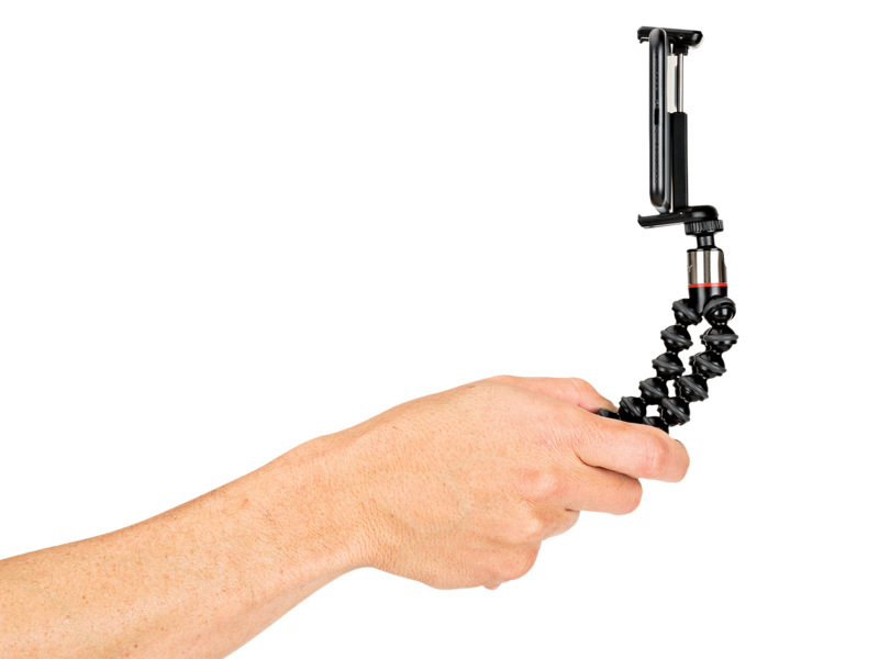 Hand holding flexible mini tripod with black bendable legs and clamp