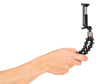 Hand holding flexible mini tripod with black bendable legs and clamp