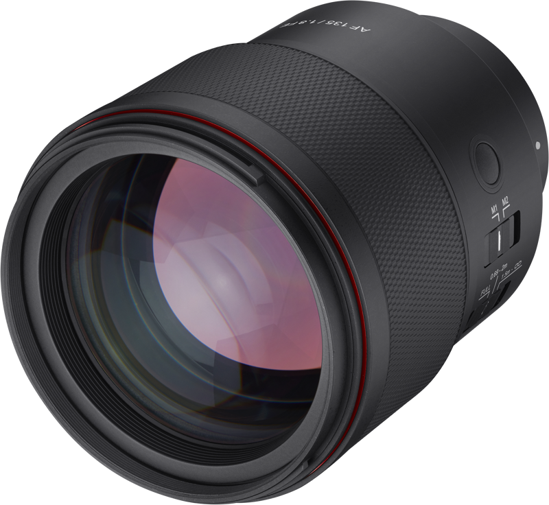 Close-up of black 135mm f/1.8 FE lens front glass, textured grip, red ring
