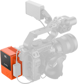 Orange V-mount battery attached to camera rig with cable connections and LCD display