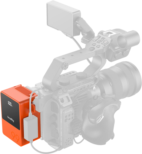 Orange V-mount battery attached to camera rig with cable connections and LCD display