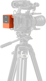 Orange V-mount battery mounted on tripod camera rig, LCD showing 100%