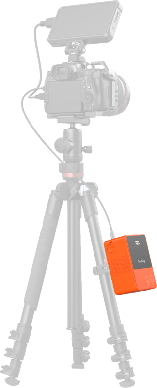 Orange V-mount battery on tripod camera setup with LCD showing 100% and cables