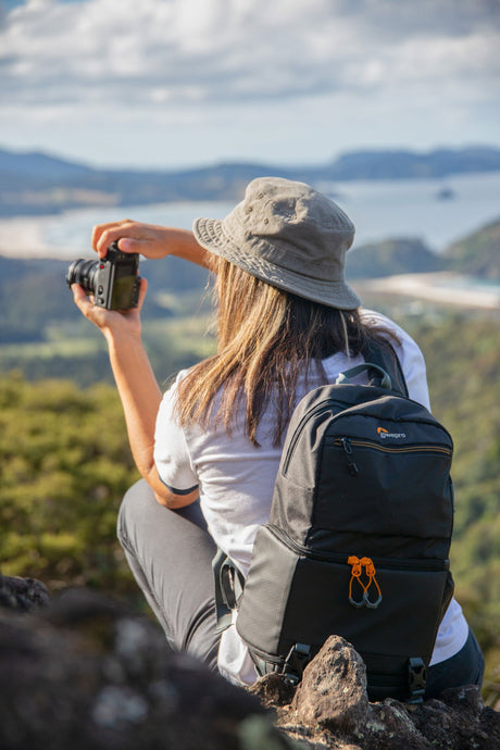Camera sling backpack worn on back with front pocket and chest strap