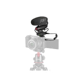 Black shotgun microphone with foam windscreen mounted on camera, cable connected
