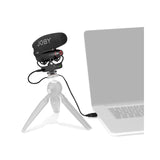 Black shotgun microphone with foam windscreen on camera rig with connected cable