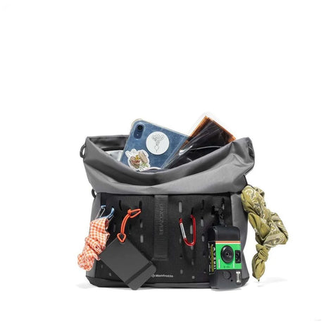 Geantă foto gri cu interior organizat, cu cameră și accesorii vizibile