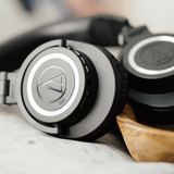 Over-ear headphones showing circular earcup control panel and speaker grille