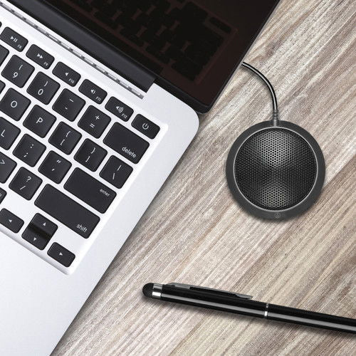 Round omnidirectional USB microphone near laptop keyboard on desk
