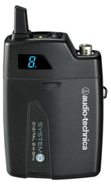 Wireless audio transmitter with antenna, dark body, small blue display and mounting clip
