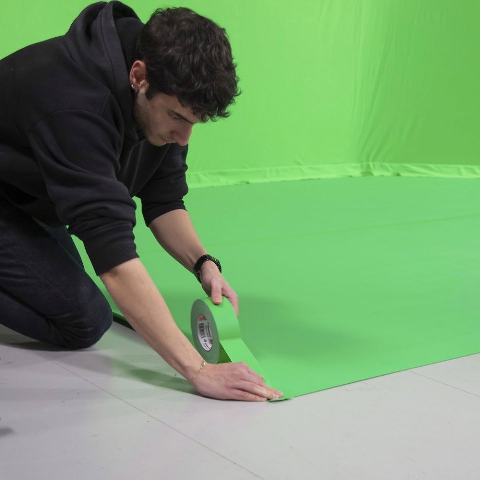 Green chroma key gaffer tape being pressed flat on the floor, 50mm x 50m