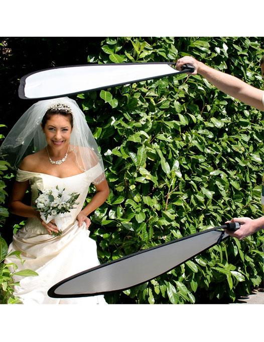 75cm triangular reflector with white inner panel, gripped above for light bounce