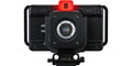 Black studio camera with front lens, top red tally, rig handles, compact body