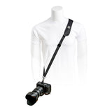 Black camera strap worn diagonally over a white shirt; adjustable buckle