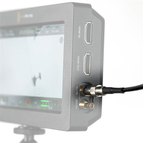 SDI cable connector inserted into rear port of monitor device, black cable