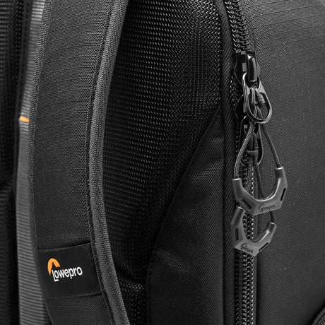 Close-up of zipper pulls and adjustable strap on the gray camera backpack