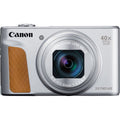 Silver compact camera with large zoom lens and brown side grip panel