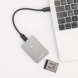 Gray CFexpress Type B card reader with USB cable and CFexpress card nearby
