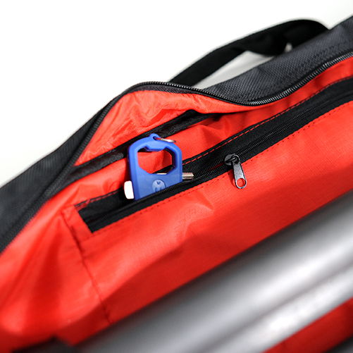 Close-up zipper on tripod bag cover, black outer with red lining and pull tab