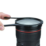 Black filter unlocking tool ring with red band; hand holds it above a lens