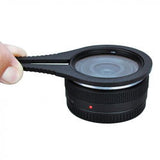 Black filter unlocking tool clamped to a camera lens, with small red indicator dot