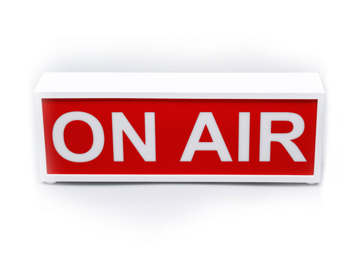 ON AIR light box sign with bold white letters on red panel, in white casing.