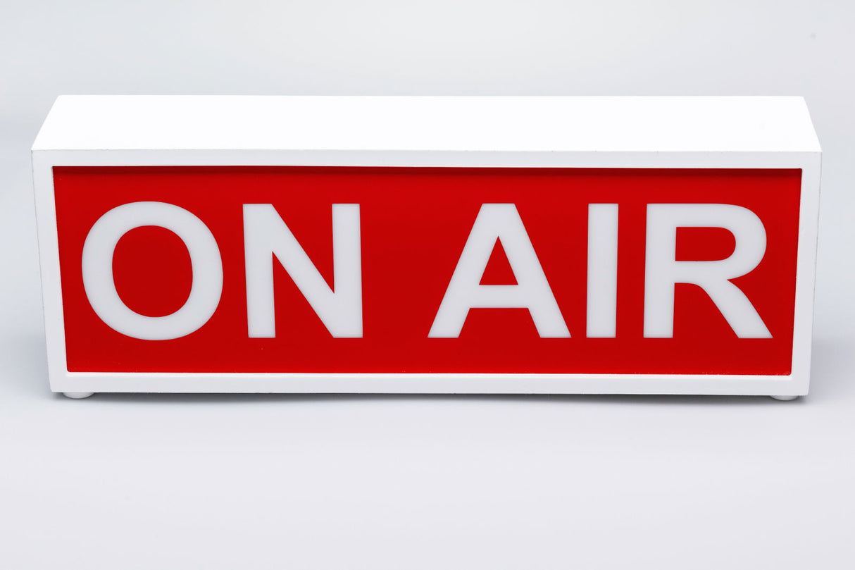 ON AIR illuminated sign with white casing, red face, and bold white “ON AIR” letters.