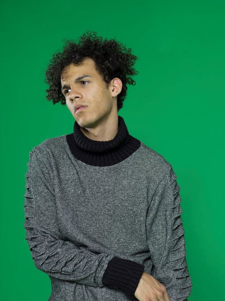 Green chroma key backdrop with person standing against it